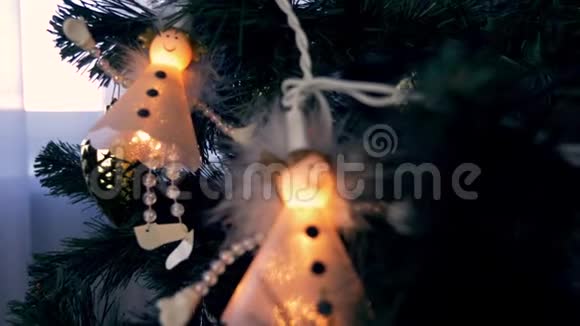 白色天使在圣诞树上徘徊圣诞节前夕和新年节日与天使们近距离拍摄小花灯视频的预览图