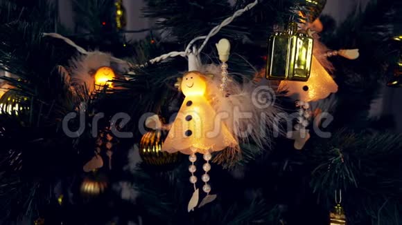 白色天使的电极挂在圣诞树上美丽可爱的白衣天使在黑暗中闪耀视频的预览图