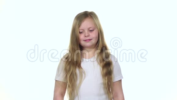 小女孩咬一根胡萝卜牙齿结实咀嚼白色背景慢动作视频的预览图