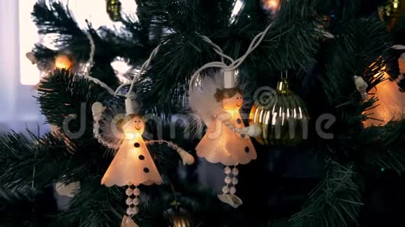 杉树上的圣诞灯带着天使的白色灯光的绿色精灵天使在圣诞树枝上游荡关闭视频的预览图
