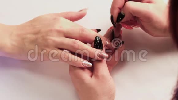 修指甲的艺术家在右手的中指上画了一条薄薄的发亮的条视频的预览图