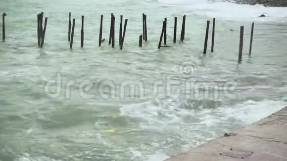 岸边的一块水泥板上有垃圾的波浪破碎视频的预览图