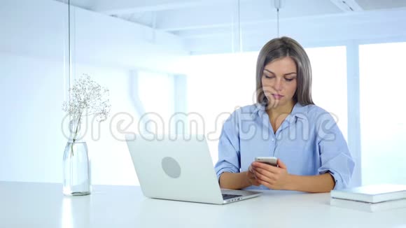 忙碌的年轻女人用智能手机打字视频的预览图