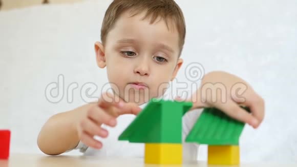 一个孩子正在用彩色积木玩耍坐在一张白色背景的桌子上动作很慢儿童和玩具视频的预览图