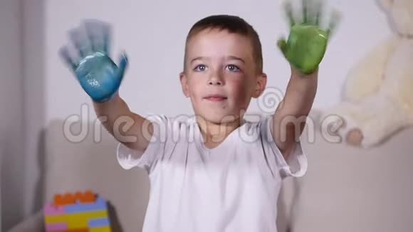 男孩在油漆中挥舞双手动作缓慢视频的预览图