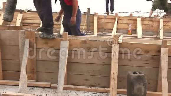 工人用软管在垂直木模中浇注新鲜混凝土连铸视频的预览图