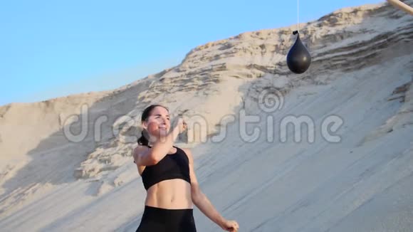运动女孩穿着黑色上衣练习踢腿脚踢在气球前面女孩用脚踢气球还有视频的预览图