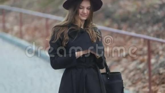 美丽的年轻快乐的女人在公园里走下来长发秋装紫色的帽子慢的莫斯坦迪卡姆射击视频的预览图
