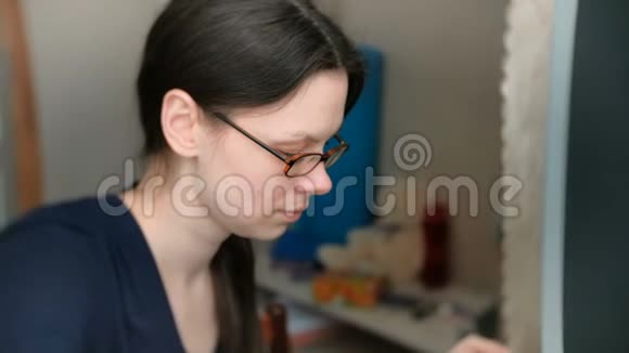 戴眼镜的黑发女人正在电脑上敲键盘视频的预览图