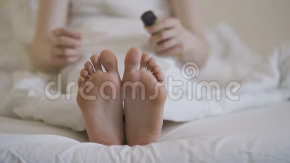 女人涂化妆品脚霜做脚按摩特写视频的预览图