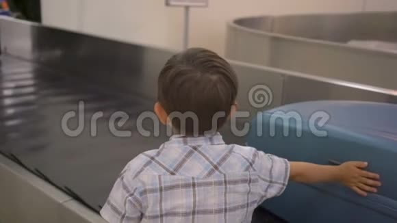 在机场行李认领处等待行李的小男孩视频的预览图