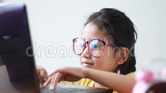 亚洲小女孩快乐地使用笔记本电脑视频的预览图