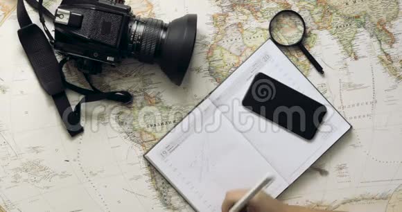 俯视图旅行者的双手在白色木桌上选择一个国家旅行的概念视频的预览图