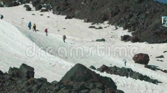 人们登山游客在高雪山陡峭的山顶上漫步视频的预览图