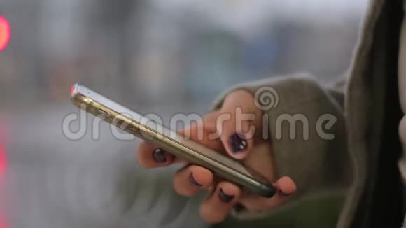 关闭一个年轻女孩的手使用智能手机键入信息视频的预览图