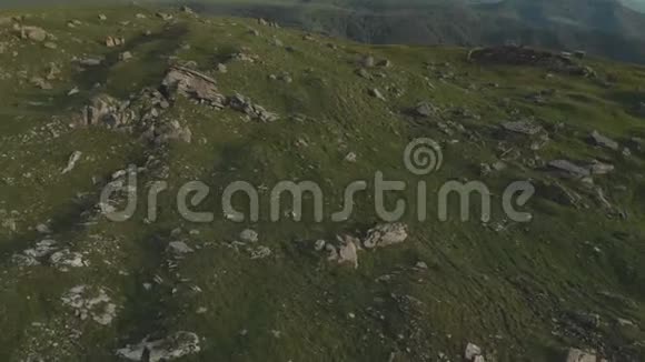 从上面看到一个山谷在一个高高的悬崖脚下散布着巨大的石头高加索山脉的日落全景视频的预览图