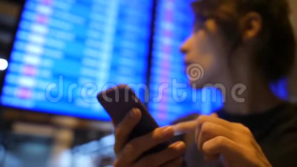 在机场离港委员会附近使用移动电话的年轻混合种族旅游女孩4K泰国曼谷视频的预览图