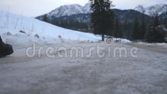 冬天的时候一个面目全非的人带着行李在下雪的路上走年轻人走在小径上翻滚视频的预览图