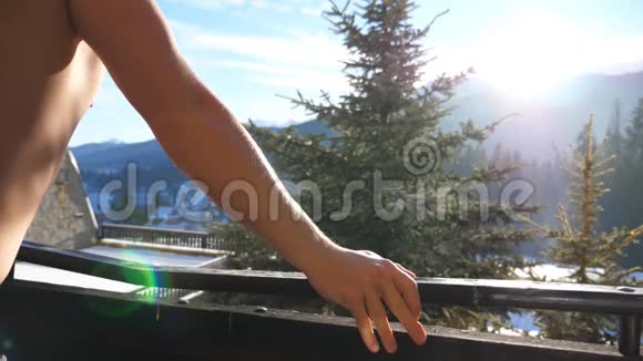 站在阳台上看阳光明媚的大自然的不知名的运动员侧视图年轻人视频的预览图