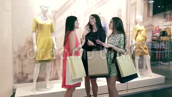 漂亮的苗条女人在购物后互相交谈视频的预览图