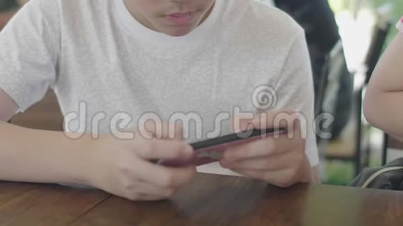 密切亚洲男孩在手机智能手机上的使用视频的预览图