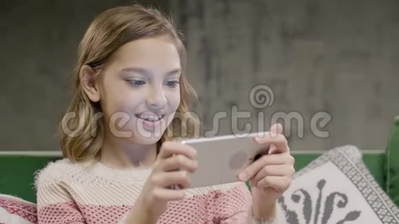 年轻女孩在智能手机上进行情感游戏视频的预览图