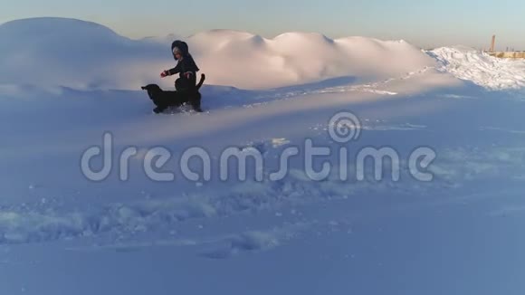 快乐的孩子在雪地里和狗玩耍视频的预览图