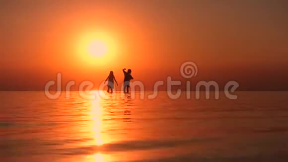 日落时孩子们在海边散步视频的预览图