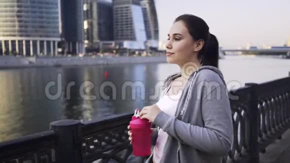 莫斯科市一名穿着运动服饮水的年轻女子视频的预览图