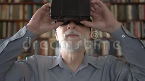 现代老人在家使用虚拟现实眼镜背景书架视频的预览图