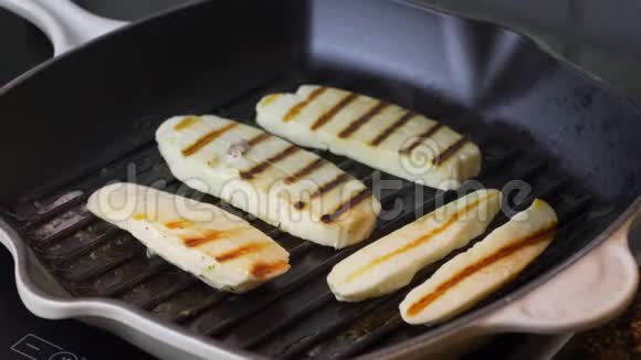 哈洛米奶酪在烤锅里煎在烤盘中煎炸的哈洛米奶酪片在室内关门塞浦路斯视频的预览图