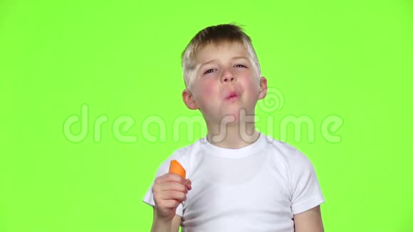 孩子们咬胡萝卜竖起大拇指绿色屏幕慢动作视频的预览图