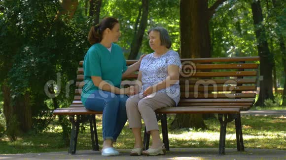 年轻的护士和公园里的老妇人度过了阳光明媚的一天视频的预览图
