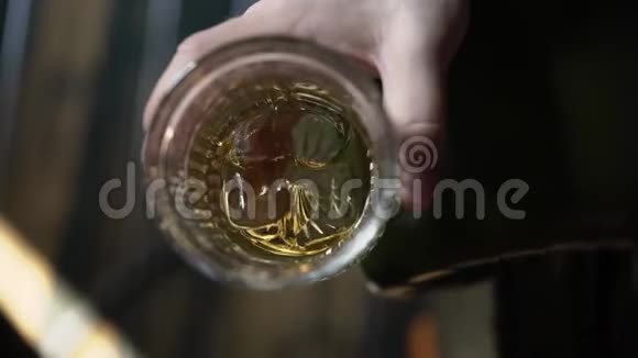 男人拿着一杯加冰的威士忌视频的预览图