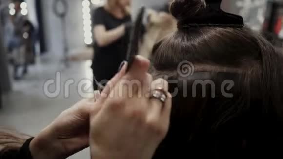 理发师把人造头发贴在真东西上发延伸的过程4K视频的预览图
