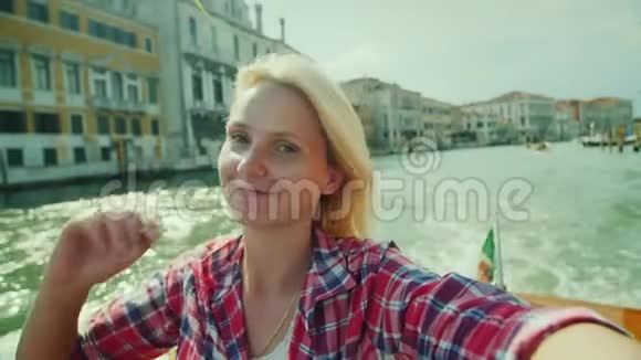 一位年轻女子正在威尼斯运河上的建筑物背景下拍摄自己的照片意大利旅游业视频的预览图