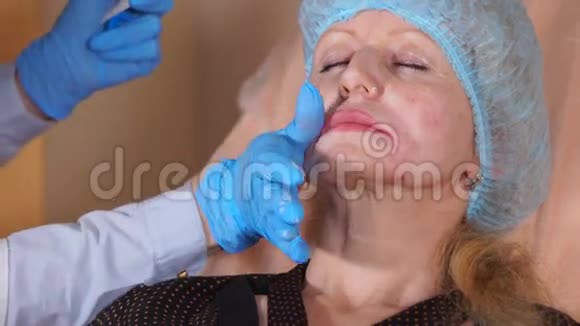 美容师把麻醉膏涂在脸上干净的皮肤上视频的预览图