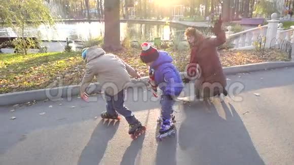 两个男孩和他的母亲骑着滚轮和滑板视频的预览图
