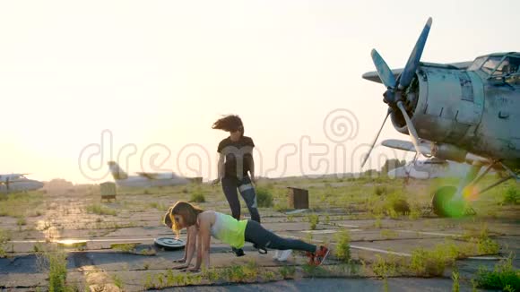 美丽运动年轻的女性戴着太阳镜穿着紧身衣同步进行不同的力量练习跳跃视频的预览图