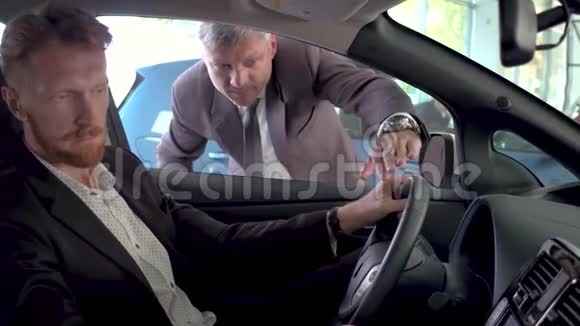 汽车经销商向年轻的帅哥展示新车视频的预览图