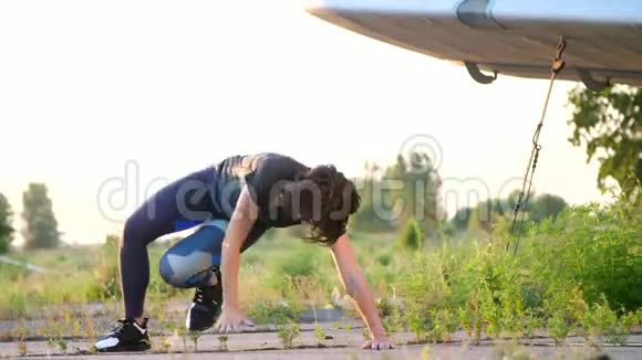 美丽运动年轻的女人戴着太阳镜穿着紧身衣做不同的力量练习跳跃俯卧撑视频的预览图