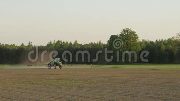 拖拉机用化学物质喷洒农田以保护作物免受杂草和害虫的侵害视频的预览图