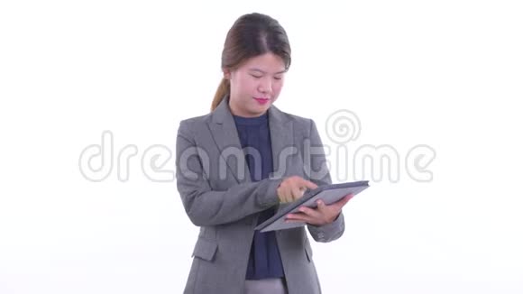 快乐年轻的亚洲女商人用数码平板电脑思考视频的预览图