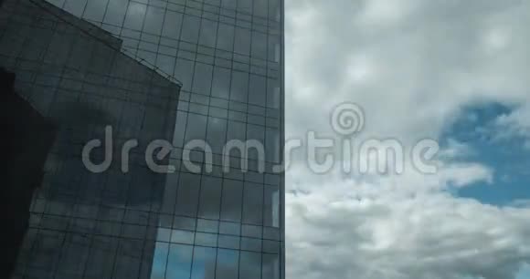在玻璃般的摩天大楼中反射出的航行云的时间视频的预览图