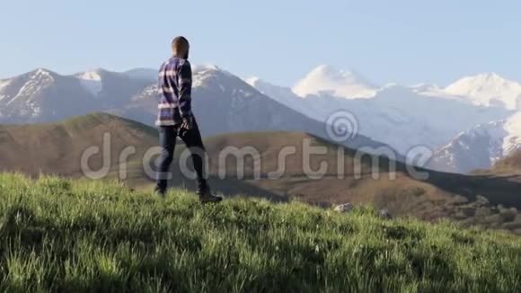 野生动物自然摄影师带着摄影相机漫步于山景视频的预览图