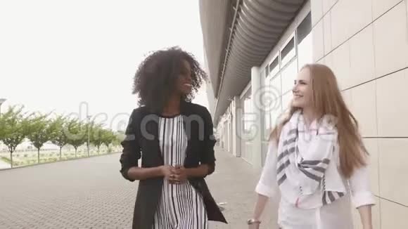 两个混合种族的年轻女性商业伙伴交谈并达成协议城市景观背景视频的预览图