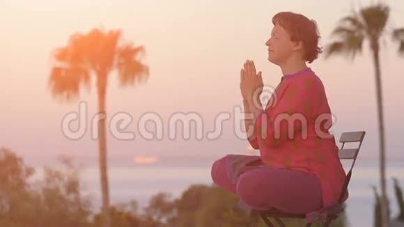 女人在日出时坐着莲花姿势健康的生活方式早上冥想瑜伽冥想的概念年轻女子视频的预览图