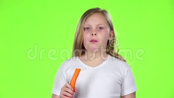 小女孩吃胡萝卜竖起大拇指绿色屏幕慢动作视频的预览图