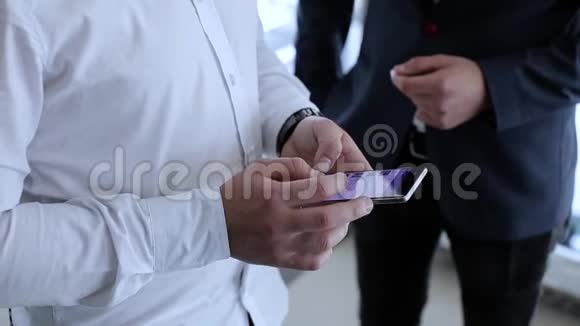 工作同事站在商业大厦用手机打字在社交网络上搜索视频的预览图