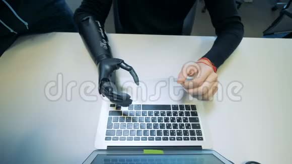 在笔记本电脑上有人工手型的人cyborg概念视频的预览图